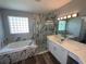 Bathroom featuring double vanity, large tub, marble accent wall and glass shower at 7628 Dunbridge Dr, Odessa, FL 33556