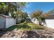 A quaint backyard with a storage shed surrounded by mature trees creating shaded areas at 8008 Somerset Ln, Tampa, FL 33615