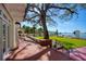 Picturesque backyard featuring a sprawling lawn, mature trees, brick patio, and waterfront view at 802 Druid S Rd, Clearwater, FL 33756