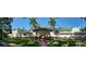 Panoramic view of an estate with lush landscaping, palm trees, and a grand entrance featuring a portico at 802 Druid S Rd, Clearwater, FL 33756