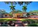 Stately home featuring lush landscaping, palm trees, and a grand entrance with a portico and green tile roof at 802 Druid S Rd, Clearwater, FL 33756