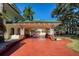 Exterior view of a home showcasing porte cochere, circular brick driveway, and lush landscaping at 802 Druid S Rd, Clearwater, FL 33756