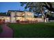 Charming home exterior at dusk, featuring a lush lawn, inviting walkway, and elegant architectural details at 802 Druid S Rd, Clearwater, FL 33756