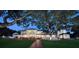 Elegant home exterior with manicured lawn, mature trees, and inviting brick walkway at twilight at 802 Druid S Rd, Clearwater, FL 33756