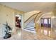 Elegant foyer showcasing marble floors, staircase, and view of a dining room through an arched doorway at 802 Druid S Rd, Clearwater, FL 33756