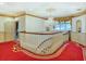 Elegant hallway featuring decorative chandelier, wainscotting, and patterned red carpet at 802 Druid S Rd, Clearwater, FL 33756