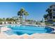 Outdoor pool area featuring clear blue water and lounge chairs overlooking the water and sunny views at 8020 Sailboat Key S Blvd # 404, St Pete Beach, FL 33707
