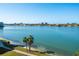 Beautiful waterfront view with palm trees, shoreline, and cityscape in the distance against a clear blue sky at 8020 Sailboat Key S Blvd # 404, St Pete Beach, FL 33707