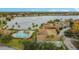 Aerial view of community featuring a pool, lake, and colorful residential buildings at 9008 Lake Chase Island Way, Tampa, FL 33626