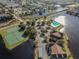Aerial view showcasing community amenities, including a pool, tennis courts, and scenic lake views at 9008 Lake Chase Island Way, Tampa, FL 33626
