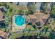 Aerial view of a community clubhouse, pool, and parking with waterfront access at 9008 Lake Chase Island Way, Tampa, FL 33626