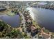 An aerial view that displays the neighborhood with lakeside homes, a pool, and scenic walking paths at 9008 Lake Chase Island Way, Tampa, FL 33626