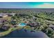 Overhead shot shows community pool, clubhouse, and surrounding greenery by the lake at 9008 Lake Chase Island Way, Tampa, FL 33626