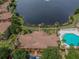 Stunning aerial view of the community clubhouse, pool, and a picturesque lake with a fountain at 9008 Lake Chase Island Way, Tampa, FL 33626