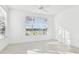 Bright, airy bedroom featuring modern flooring and large windows with serene lake views at 9008 Lake Chase Island Way, Tampa, FL 33626