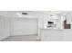 Modern kitchen with white cabinetry, stainless steel appliances, and adjacent living area at 9008 Lake Chase Island Way, Tampa, FL 33626