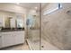 Bright bathroom featuring a tiled shower with glass door and vanity with granite countertop at 10106 Corso Milano Dr, Tampa, FL 33625
