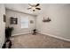 Neutral bedroom includes ceiling fan, window with blind, and dark work out equipment at 10106 Corso Milano Dr, Tampa, FL 33625