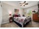 Comfortable bedroom featuring an iron bed frame, ceiling fan and window with natural light at 10106 Corso Milano Dr, Tampa, FL 33625