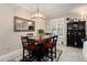Cozy dining area with wood table, stylish rug, and elegant light fixture near a window and black cabinet at 10106 Corso Milano Dr, Tampa, FL 33625
