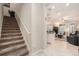 Inviting entryway with carpeted stairs, and a glimpse of the open-concept living area with modern design at 10106 Corso Milano Dr, Tampa, FL 33625