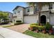 Charming two-story townhome with a brick driveway, attached garage, landscaped front yard, and inviting curb appeal at 10106 Corso Milano Dr, Tampa, FL 33625