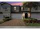 Townhouse exterior with brick driveway, a garage, landscaping and tropical plants at 10106 Corso Milano Dr, Tampa, FL 33625