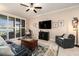 Comfortable living room with a TV, cozy seating, stylish rug and plenty of natural light from the windows at 10106 Corso Milano Dr, Tampa, FL 33625