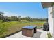 Spacious backyard featuring a modern patio set, a grill, and views of a serene pond, perfect for relaxation and outdoor enjoyment at 11944 Miracle Mile Dr, Riverview, FL 33578