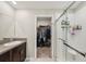 This bathroom features granite countertops, a glass enclosed shower, and a walk-in closet at 11944 Miracle Mile Dr, Riverview, FL 33578