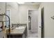 Functional bathroom featuring granite counters, a large mirror, and direct access to the laundry room at 11944 Miracle Mile Dr, Riverview, FL 33578