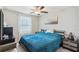 This bedroom has a ceiling fan, a window with white curtains, and a blue bed at 11944 Miracle Mile Dr, Riverview, FL 33578