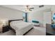 Bright bedroom with a ceiling fan, large bed, plush ottoman, and window with curtains for a serene atmosphere at 11944 Miracle Mile Dr, Riverview, FL 33578