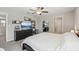 Well-lit bedroom with a ceiling fan, dresser with a TV, décor shelves, and a mirrored closet door at 11944 Miracle Mile Dr, Riverview, FL 33578