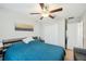 This bedroom features a ceiling fan, a closet, and a bed with a blue blanket at 11944 Miracle Mile Dr, Riverview, FL 33578