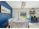 Dining room with white chairs, blue accent wall, and sliding glass door to the outdoors at 11944 Miracle Mile Dr, Riverview, FL 33578