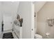Hallway with a view of a half bathroom, white door and a decorative furniture piece at 11944 Miracle Mile Dr, Riverview, FL 33578