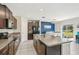 Modern kitchen featuring granite countertops, stainless steel appliances, dark brown cabinets, and a dining area with a blue accent wall at 11944 Miracle Mile Dr, Riverview, FL 33578