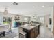 Bright kitchen featuring a center island with a granite countertop and modern finishes, with an easy flow into the living room at 11944 Miracle Mile Dr, Riverview, FL 33578