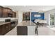 Well-lit kitchen with granite countertops, stainless appliances, dark brown cabinets, and a dining area with a blue accent wall at 11944 Miracle Mile Dr, Riverview, FL 33578