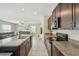 Modern kitchen with sleek dark brown cabinets, stainless steel appliances, and granite countertops with an open layout at 11944 Miracle Mile Dr, Riverview, FL 33578