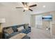 This living room features a ceiling fan, a blue sectional couch, and a wall-mounted TV at 11944 Miracle Mile Dr, Riverview, FL 33578