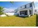 Backyard with well-maintained lawn, white vinyl fencing and a covered patio at 12294 Cypress Branch St, Riverview, FL 33579