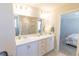 Bright bathroom featuring dual sinks, white cabinetry, and a view of the glass door shower at 12294 Cypress Branch St, Riverview, FL 33579