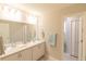 Bright bathroom featuring double vanity sinks, tile floors, and a door leading to the toilet at 12294 Cypress Branch St, Riverview, FL 33579