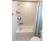 Bright bathroom featuring a shower and a bathtub with blue curtains and tiled walls at 12294 Cypress Branch St, Riverview, FL 33579
