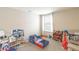 A bedroom featuring a window, carpet, and a colorful toddler bed surrounded by shelves and toys at 12294 Cypress Branch St, Riverview, FL 33579