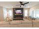 Cozy living room with a large sectional sofa, modern electric fireplace, and bright windows at 12294 Cypress Branch St, Riverview, FL 33579