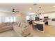 Comfortable living room features a sectional sofa and transitions seamlessly into a modern kitchen with an island and barstools at 12294 Cypress Branch St, Riverview, FL 33579
