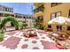 Charming courtyard featuring colorful tiled floors, tables with umbrellas, and mature landscaping at 130 4Th N Ave # 315, St Petersburg, FL 33701